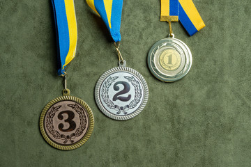 Gold, silver or bronze medal with yellow and blue ribbons
