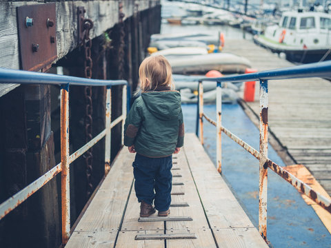 Little toddler walking around a marina