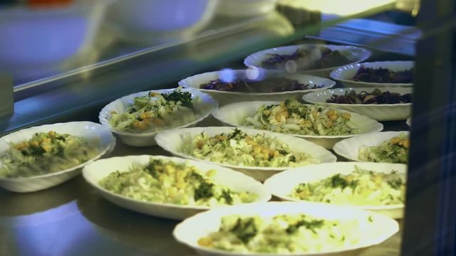 close-up, showcase with salads in modern canteen, cafeteria, dining room resturant, restaurant of public catering. salads with cabbage and corn for buffet catering In mess hall, Food Buffet resturant