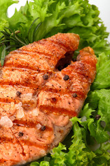 Salmon steak grilled with lemon.Sea salt.On leaf of salad.