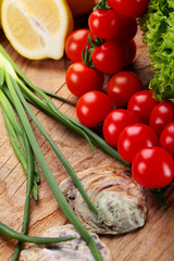 Cherry tomatoes , green onion, lemon leaf of salad on a wooden surface.Vegetables