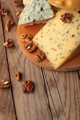 Various types of cheese on wooden board.Copy space.Chessnut.