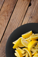 Fresh lemon.Slice of lemon on black plate.Top view.Copy space.