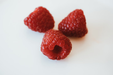 Raspberries on white background. Close up view of fresh and sweet raspberries. 