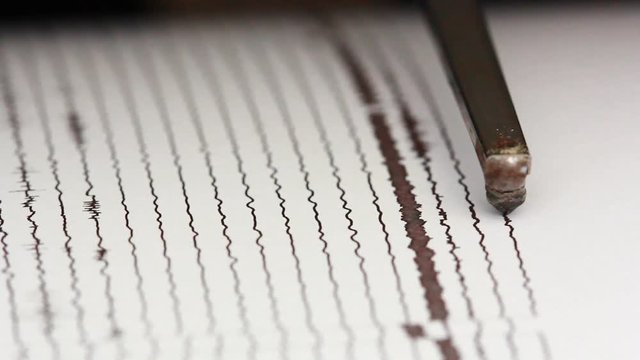 close up drum recorder recording seismic signal on paper