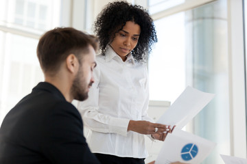 Team leader and colleague looking at statistics shown on document