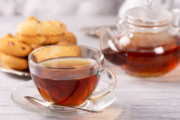 transparent teapot and cup of hot tea