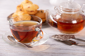 transparent teapot and cup of hot tea