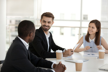 Diverse coworkers chatting during break sitting in conference room