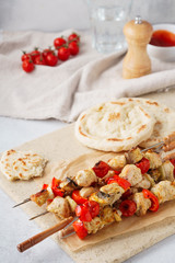 Chicken and mushrooms shish kebab on skewers and fresh pitas.