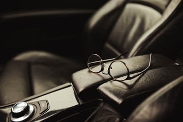 driver's glasses on the leather upholstery of the car.