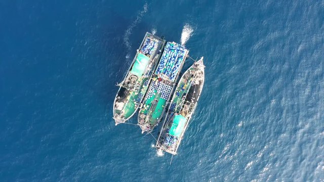 Industrial overfishing - aerial view of a fleet of large fishing trawlers operating together in a shallow ocean (Black Rock, Mergui Archipelago)