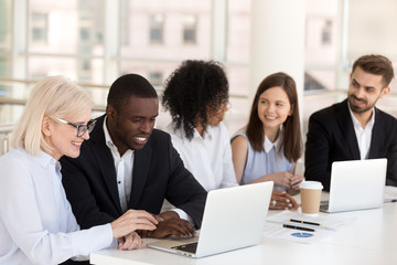 Obraz premium Diverse workers sitting at desk communicating during break 
