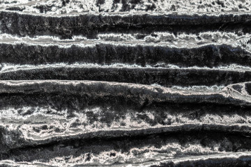 Grey, pinkish, purple velvet background. Soft textile fabric, pleasant to the touch. Delicate material, crumpled and collected in different directions. In the light with shadows.  Pronounced texture.