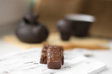 chocolate candies on clay teapot background