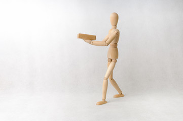 Wooden doll carrying a box