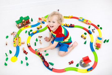 Obraz premium Child with toy train. Kids wooden railway.