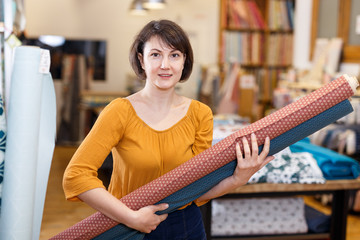 Saleswoman arranging cloth rolls