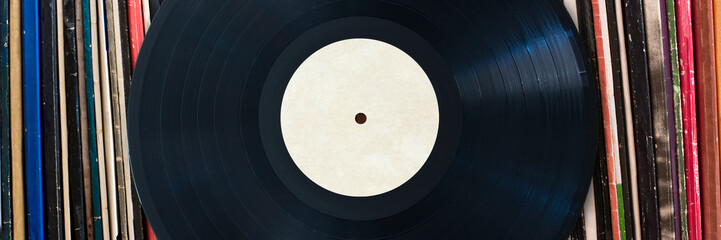 Vinyl record with copy space in front of a collection of albums, vintage music concept