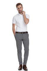 Fototapeta premium full body picture of a young man fixing his collar