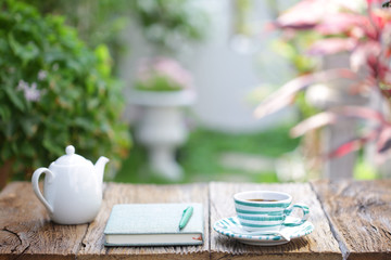 Blue stripes cup pattern with white kettle on and notebook on wooden table