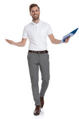 happy casual man holding a clipboard is walking and welcoming