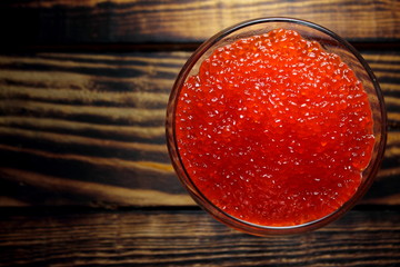 Red salmon caviar in a glass goblet, top view
