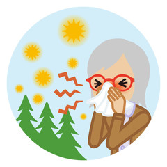 ティッシュで鼻をかむシニア女性　屋外背景　円形 - 花粉症イメージ