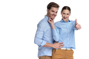 embraced happy casual couple, woman makes the ok sign