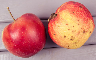 Fresh and old apple on a wooden background. CloseUp.
