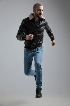 man in leather jacket and jeans jumping