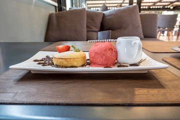 Side view of white chocolate lava cake served with strawberry ice-cream and sauce isolated.
