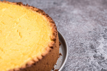 Tasty homemade vegan lemon cheesecake on dark gray plate
