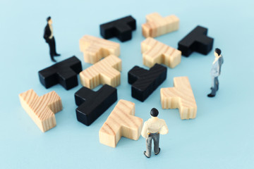 puzzle blocks with miniature people over wooden table ,human resources, problem solving and management concept
