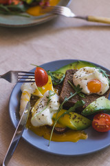 sandwich with avocado, poached egg, arugula and cherry tomatoes