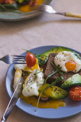 sandwich with avocado, poached egg, arugula and cherry tomatoes
