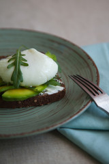 sandwich with avocado, poached egg, arugula and cherry tomatoes