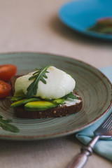 sandwich with avocado, poached egg, arugula and cherry tomatoes