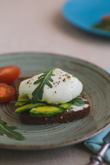 sandwich with avocado, poached egg, arugula and cherry tomatoes