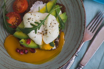 sandwich with avocado, poached egg, arugula and cherry tomatoes