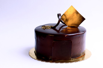  Tasty little chocolate cake with golden decoration details.