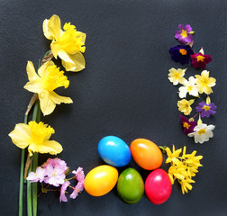 Ostern, Osterdekoration mit Ostereiern und Frühlingsblumen auf Schiefer, Textraum, copy space