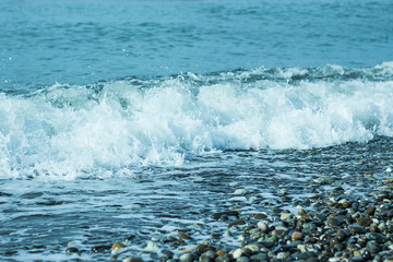 Beautiful foam waves on a sunny day in the Aegean Sea on the island of Evia in Greece
