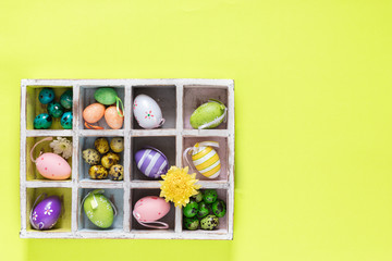 Colourful Easter Eggs in a Wooden Box on bright  green background, top view - Image