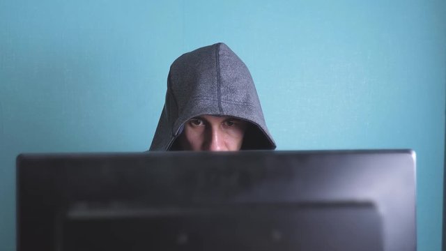 man hacker in lifestyle the hood hacking network concept. unknown hacker criminal breaks into computer protection on the Internet passwords. male hacker penetrates into hack network protection web
