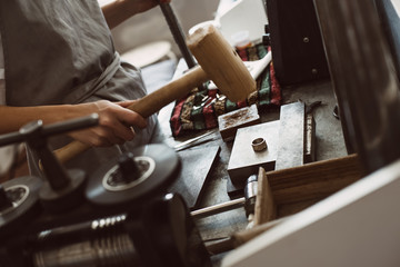 A good ball. Close up of female jeweler making a silver ring using a hammer
