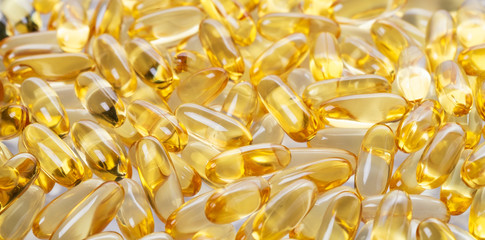 yellow fish oil capsules, omega 3, on white background