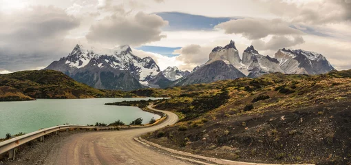 Deurstickers Cuernos del Paine Onverharde weg die rond het meer leidt naar het prachtige Cuernos del Paine in Patagonië. Torres del Paine National Park, Patagonië, Chili het berglandschap onder de bewolkte regenachtige en blauwe hemel. Op reis.