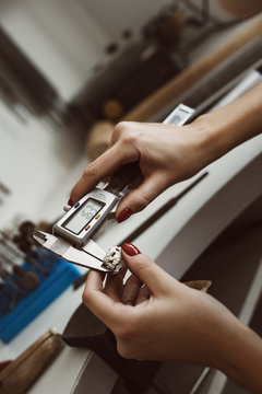 Do It Right. Close Up Photo Of Female Jeweler's Hands Measuring Ring With A Tool In Workshop.