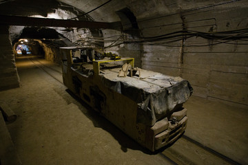 Underground gold ore mine shaft tunnel gallery passage with electric locomotive
